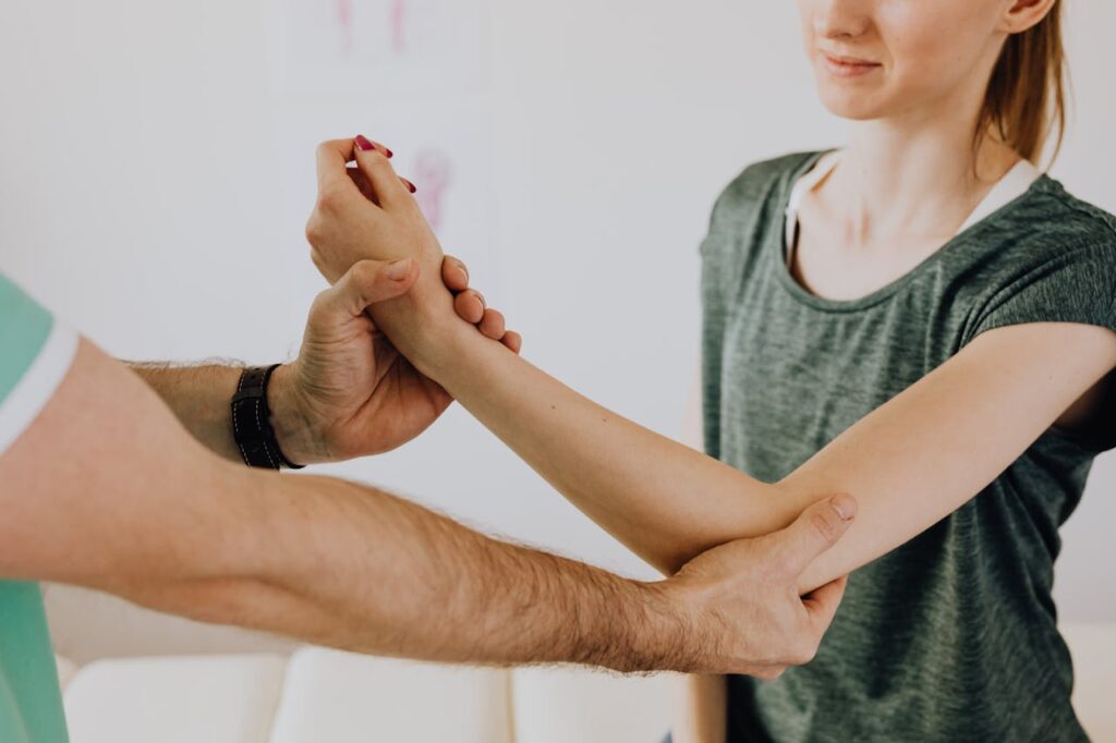 Image of a physiotherapy session focusing on arm movement and manual adjustment.